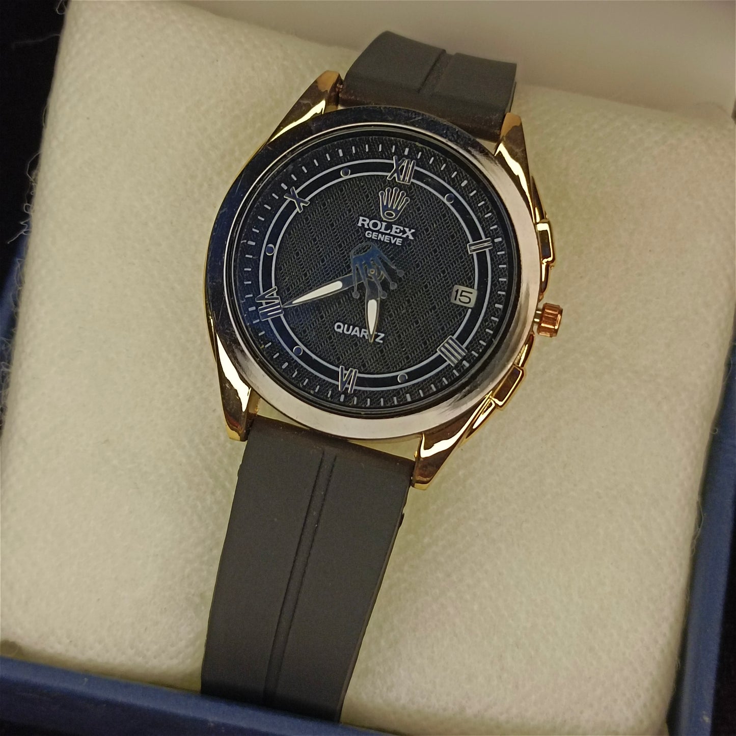 Black watch with black face and gray strap on a beige cushion by Janxy