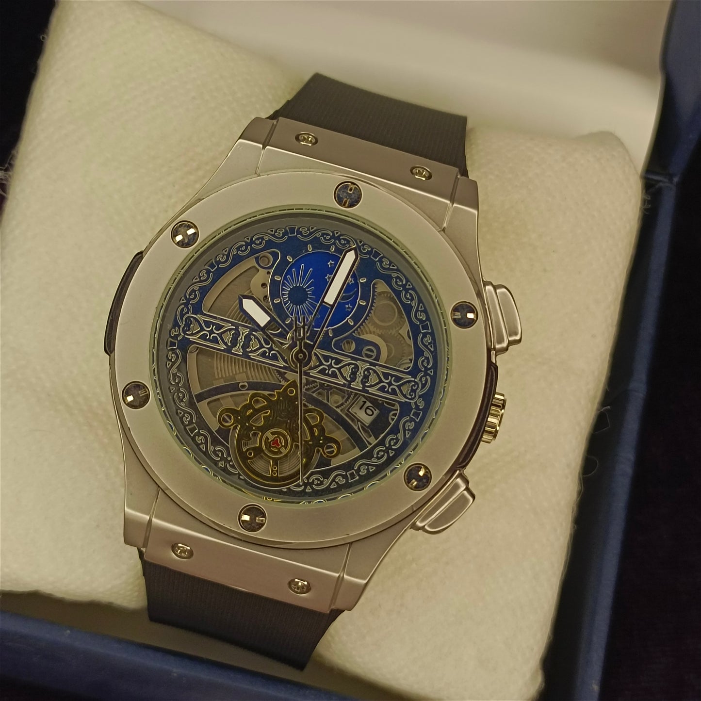 Luxury watch with intricate design on a beige cushion