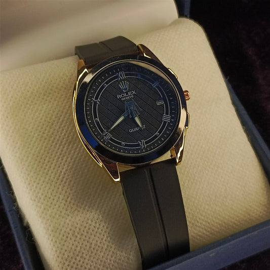 Luxury watch with black strap and gold case on a textured surface by Janxy Jewels