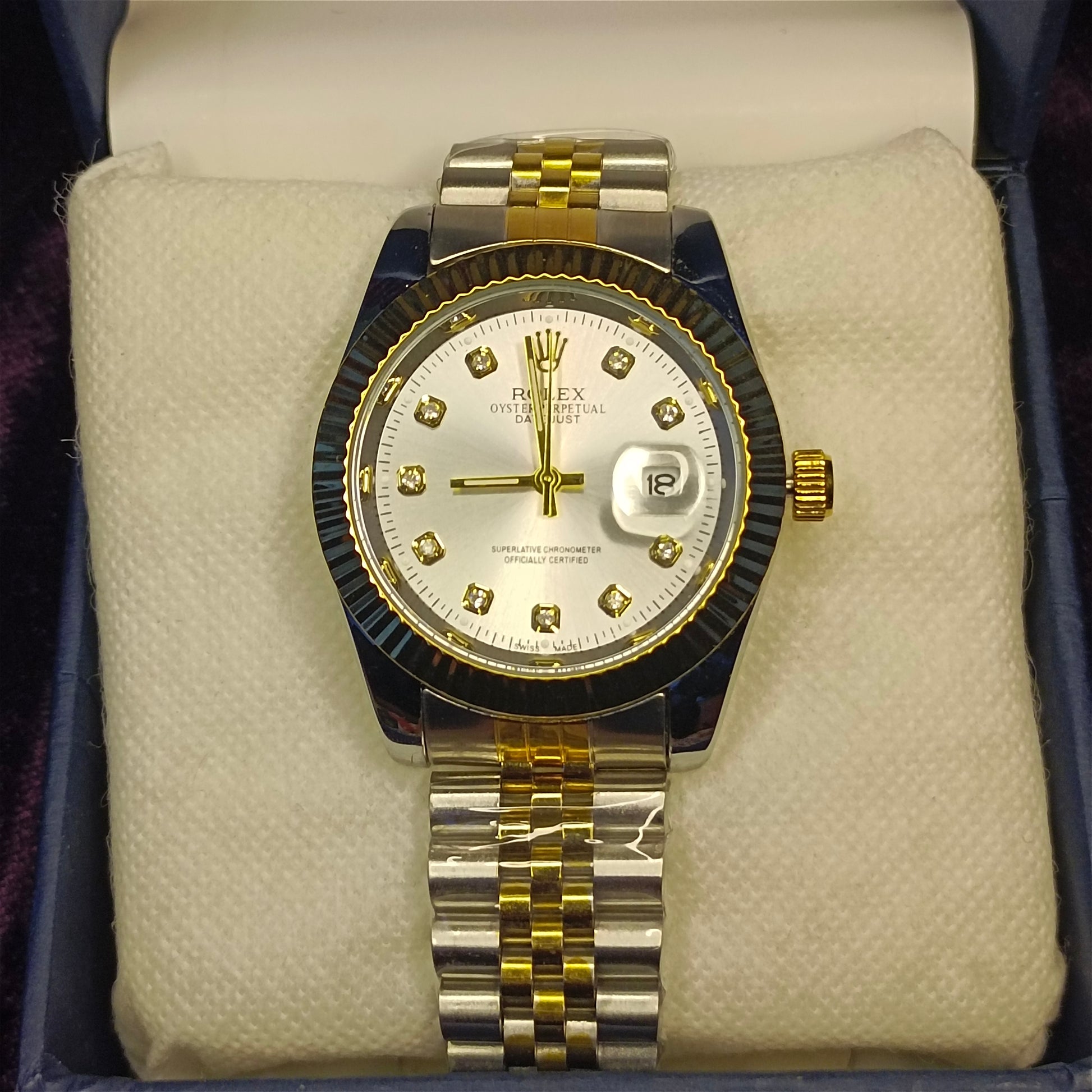 Two tone watch in gold and silver on foam in a blue box. View from above